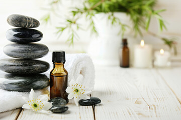 Fototapeta na wymiar Beautiful spa composition with stones and oil bottles on wooden background
