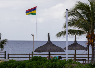 Sun umbrella and beach beds on tropical coastline, in Mauritius