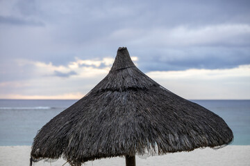 Sun umbrella and beach beds on tropical coastline, in Mauritius
