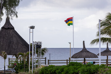 Sun umbrella and beach beds on tropical coastline, in Mauritius