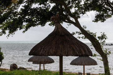 Sun umbrella and beach beds on tropical coastline, in Mauritius