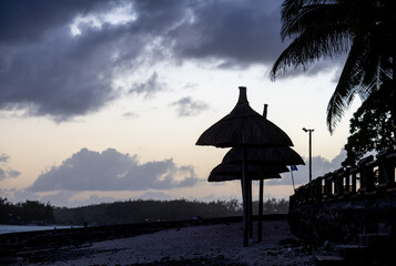 Sun umbrella and beach beds on tropical coastline, in Mauritius