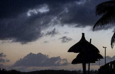Sun umbrella and beach beds on tropical coastline, in Mauritius