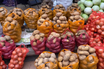 Potatoes in bags and in net. Packaged potatoes on the counter