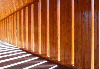 Lights and shadows in the hallway. Wall of planks with symmetrical distances where sunlight...