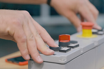Pressing buttons on the machine control panel. Production & Control Panels