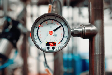 Pressure gauge on milk pipeline. Pipe pressure monitoring devices.