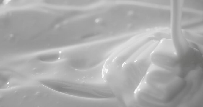 Closeup shot of white cream or body lotion drop on skin care background with abstract wave.
