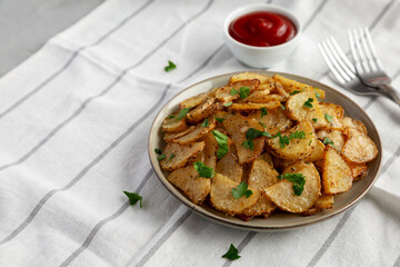 Homemade Roasted Garlic Parmesan Potatoes on a Plate, side view. Copy space.