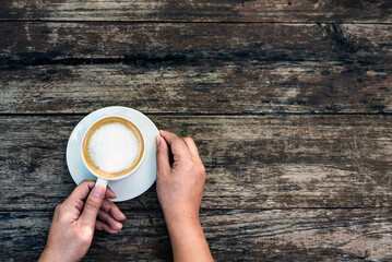 Flat Lay Hot cappuccino cup in hand,Woman Hand Holding Coffee capucino,Top view