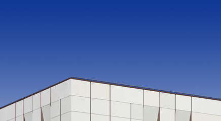 Top edge of a modern building and blue sky