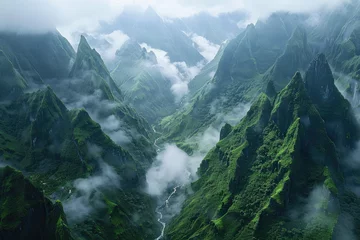  Cinematic shot of the view from above, looking down at an epic mountain range with clouds rolling over and mist hanging in between mountains, green grass on cliffs © Kien