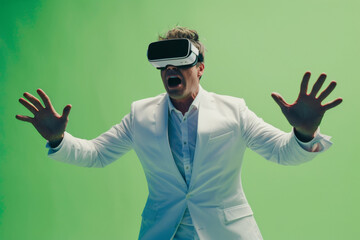 Man in white suit experiencing Virtual Reality on green background.