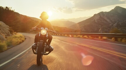 motorcyclist riding a bike free on a desert road landscape at sunset 