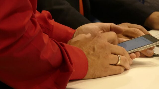 Man's hands in a red shirt with a smartphone at IFA, Messe, Berlin, Germany
