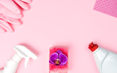 Spring cleaning. Detergent, cleaning products, kitchen sponges and rubber gloves lie in the shape of a frame on a pink background. Top view. Flatlay. Copy space.