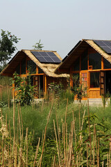 Obraz premium Houses constructed from grass, equipped with solar panels on the roof