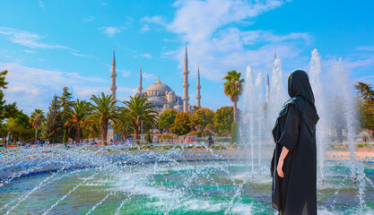 Young girl in traditional abaya clothes 
enjoying the view Blue Mosque - The Blue Mosque (Sultanahmet Camii), Istanbul, Turkey
