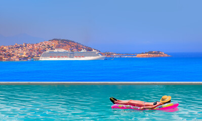 Girls in bikini lying on air bed in the turqouise pool - The cruise ship is located on Kusadasi Island in the port of Kusadasi, Turkey