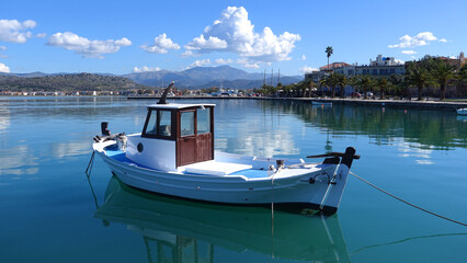 Fototapeta na wymiar Traditional fishing boats anchored in small port of Nafplio city, Argolida, Peloponnese, Greece