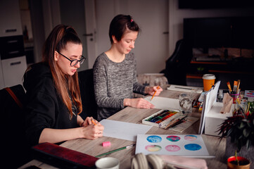 A heartwarming scene of two friends laughing and enjoying their artistic hobbies together at a...