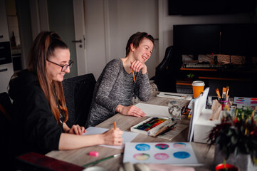 A heartwarming scene of two friends laughing and enjoying their artistic hobbies together at a...