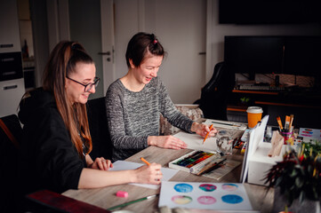 A heartwarming scene of two friends laughing and enjoying their artistic hobbies together at a...