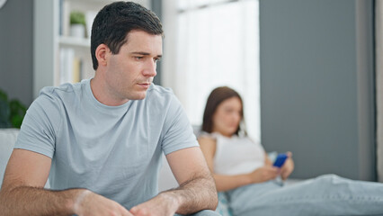 Obraz premium Beautiful couple sitting on sofa silent with problem using smartphone at home