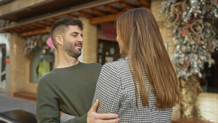 Fototapeta premium Affectionate couple embracing lovingly on a city street, portraying a romantic relationship in an urban outdoor setting.