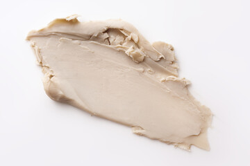 Close-up view of a textured beige cosmetic clay smear