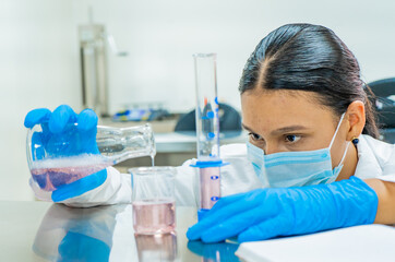 mujer latina trabajando en pruebas quimicas y de ciencia para su proyecto y experimento 