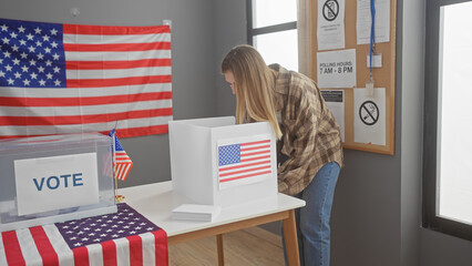A young woman casting her ballot at a usa election polling station with an american flag in the...