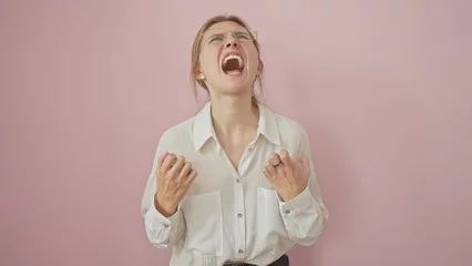 Fototapete Rund Young caucasian woman in a white shirt yelling with a frustrated expression against a pink background © Krakenimages.com