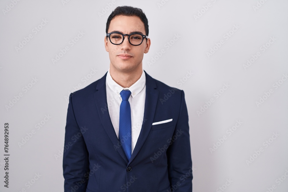 Sticker Young hispanic man wearing suit and tie relaxed with serious expression on face. simple and natural looking at the camera.