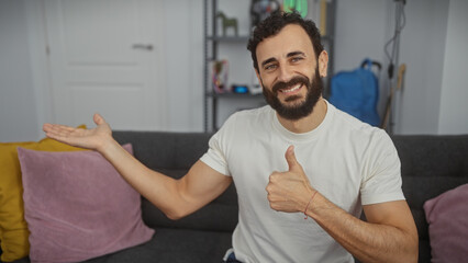 Handsome bearded man in a living room giving a thumbs up and gesturing welcomingly, exuding a...