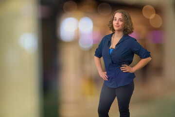 young woman brunette curly hair student standing in bokeh blur copy space background