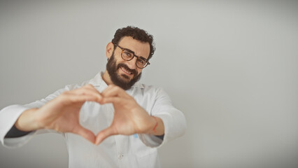 Smiling bearded man forming heart shape with hands against isolated white background