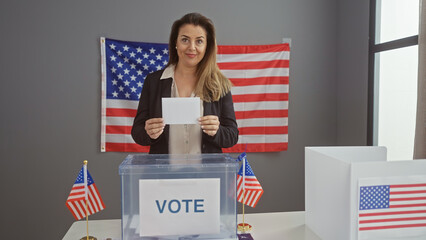 A hispanic woman casts her ballot at an indoor united states electoral center, implying democracy...