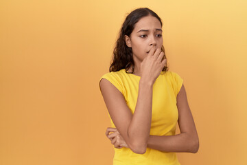 Young african american woman standing with nervous expression over isolated yellow background