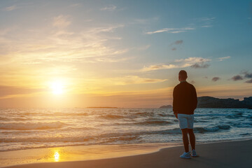Fototapeta premium Man traveller on a tropical beach during sunset. Holiday vacation and travel concept.