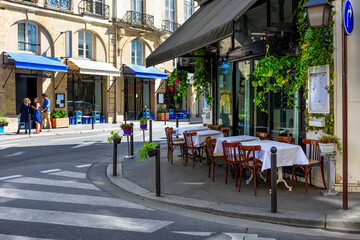 Cozy street with tables of cafe  in Paris, France. Cityscape of Paris. Architecture and landmarks of Paris - 764915704