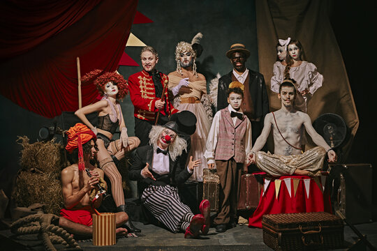 Diverse cast of vintage circus performers poses over dark retro circus backstage background. Promotional poster for upcoming performances. Concept of circus, theater, performance, show, retro and