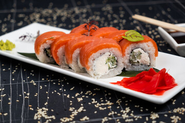 Sushi roll (Philadelphia) with salmon, smoked eel, avocado, cream cheese on black background. Sushi menu. Japanese food.