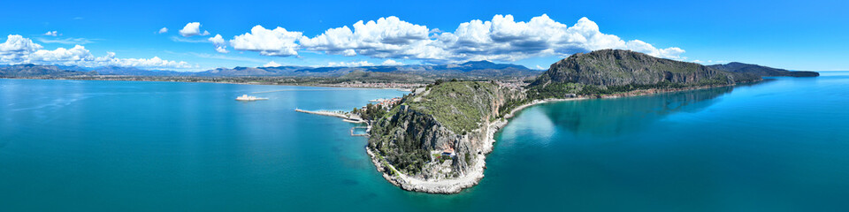 Aerial drone photo of iconic Acronafplia fortress overlooking old city of Nafplio below famous castle of Palamidi as seen in a spring morning with beautiful clouds and deep blue sky, Argolida, Greece - obrazy, fototapety, plakaty