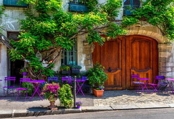 Fototapeta na wymiar Cozy street with tables of cafe in Paris, France. Cityscape of Paris. Architecture and landmarks of Paris