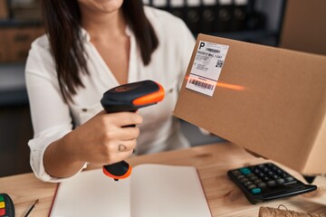 Young beautiful hispanic woman ecommerce business worker scanning package at office