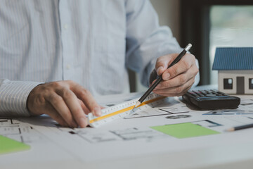 An engineer is working in his office and using various equipment to help with his work. An architect is working in a transparent office filled with documents and a nice atmosphere.