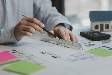 An engineer is working in his office and using various equipment to help with his work. An architect is working in a transparent office filled with documents and a nice atmosphere.