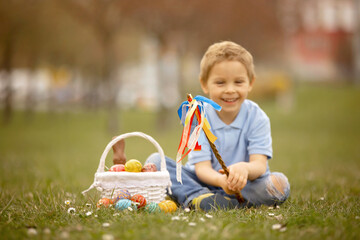 Cute preschool child, whipping his sister on Easter with twig, braided whip made from pussy willow,...