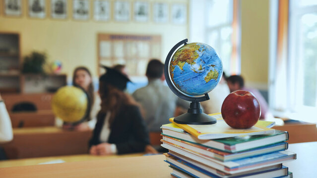 A globe of the world in a school classroom during a lesson. The globe shows Asia.